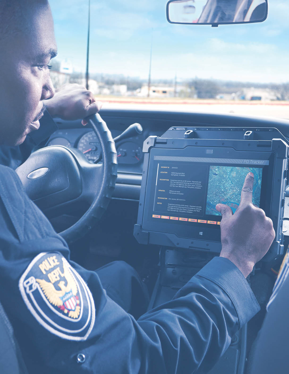 Two police officers in the front seat of a parked police car  male driver using a Dell Latitude 12 Rugged Extreme  Model 7214  notebook computer  codename Columbus II   to access tracking software 