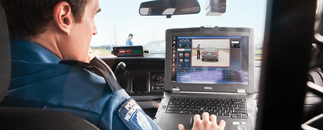 Male police officer in vehicle using Dell notebook computer with dashboard camera showing another male police officer  who is also visible through vehicle s windshield  Dell Photo Shoot in Killeen Texas  Ad Agency - Y R SanFrancisco  Art Director - Juan Contreras 