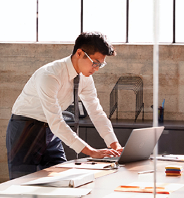Businessman working alone in a office, seen through window 