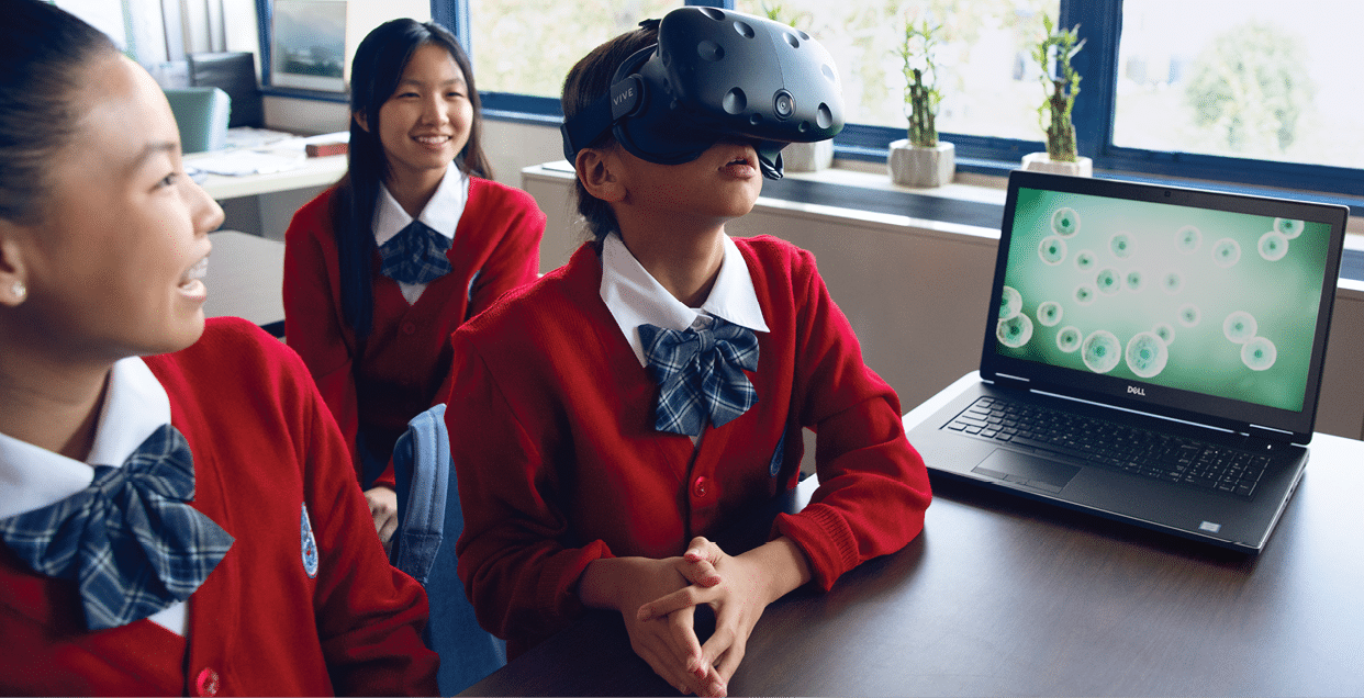 A group of Chinese school girls interacting with a VR headset and laptop 