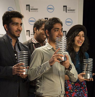 Group of four people holding Webby Awards and posing for photos