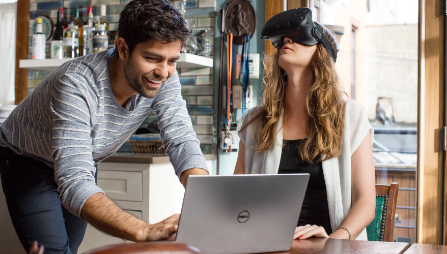 Adrian Grenier with Dell laptop and girl in VR headset