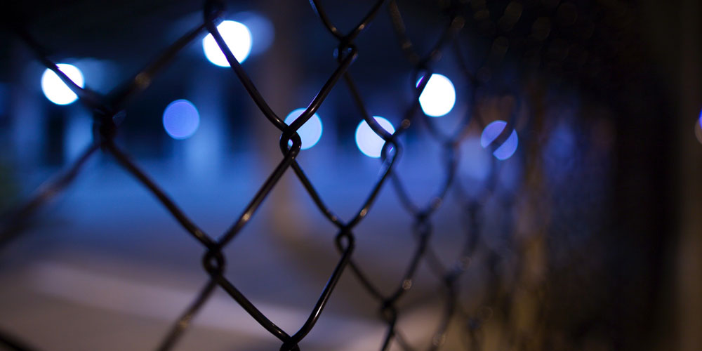 blue lights seen through a fence