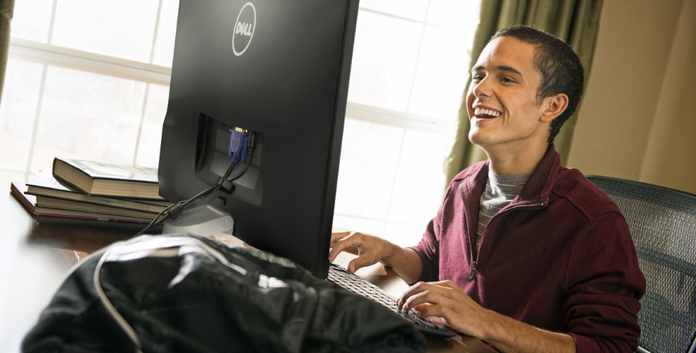 guy sitting at a desk in front of a Dell monitor