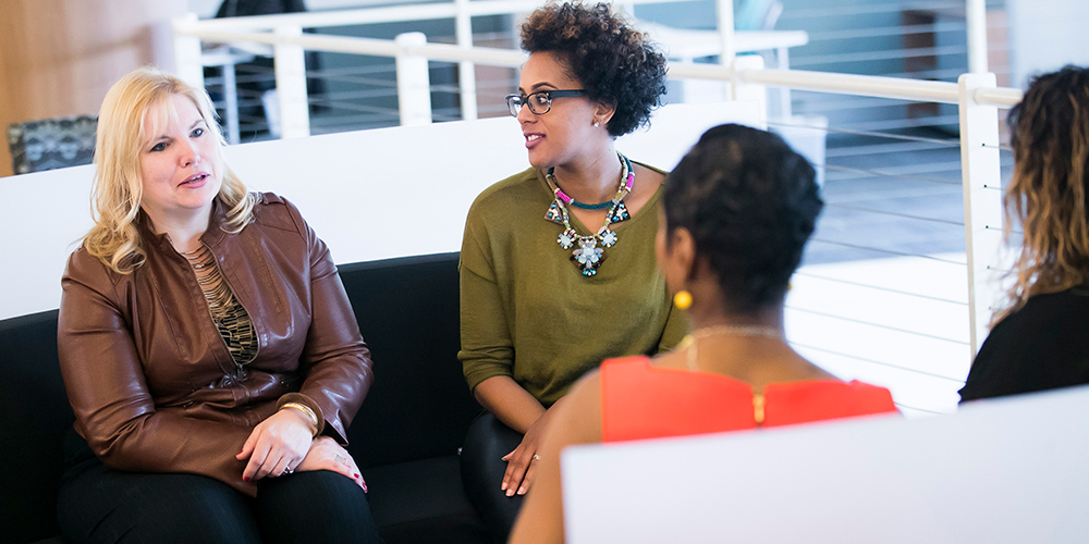 four women seated talking