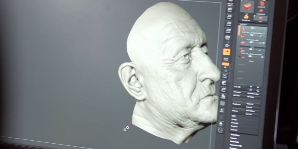 a man's face being drawn in computer animation as seen on a Dell monitor