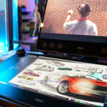 Dell canvas with car illustrations on it in front of a Dell monitor with image of man in vr headset