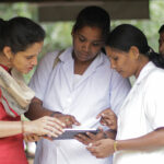 four Indian women looking at a tablet