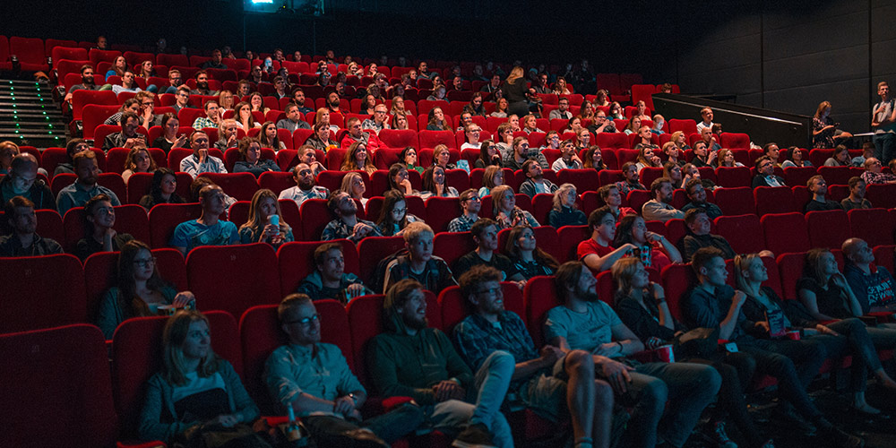 people sitting inside a movie theater Photo by Krists Luhaers on Unsplash