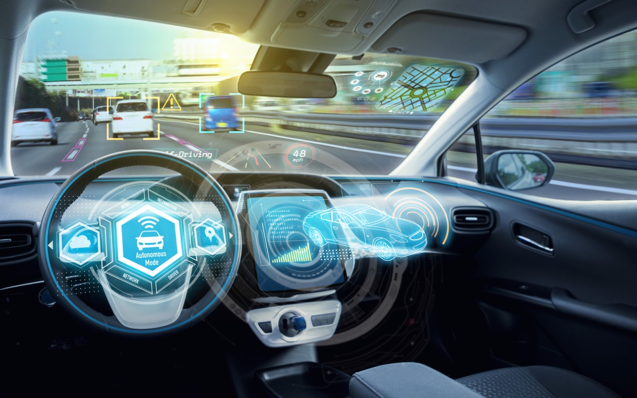 Car interiour with images of high tech graphics over steering wheel, radio controls, for example of autonomous car function