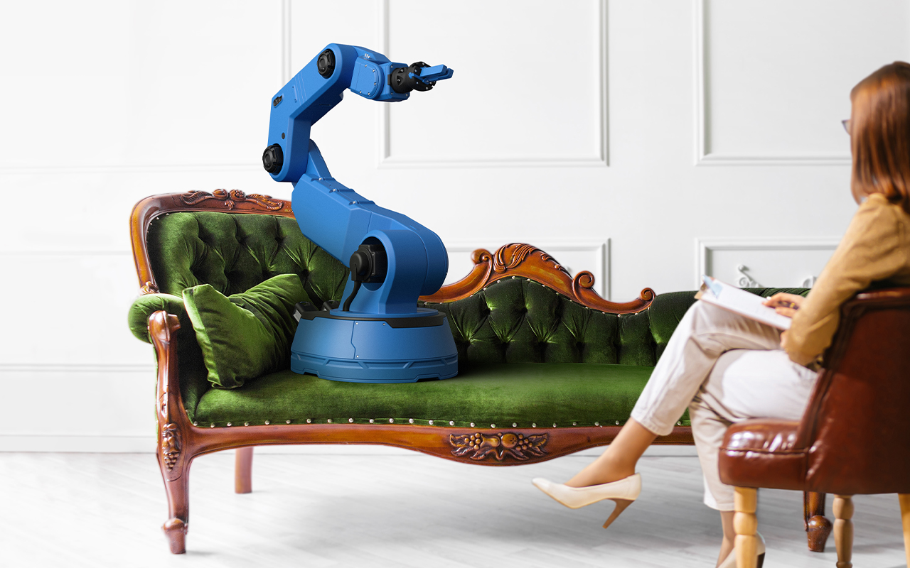 an industrial robot sits on a sofa while a woman with a clipboard takes notes