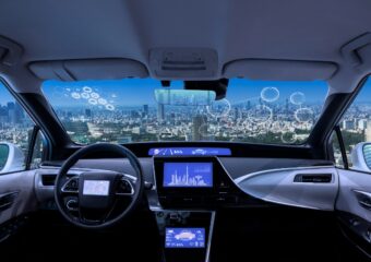 Autonomous car interior with panoramic view of city skyline.
