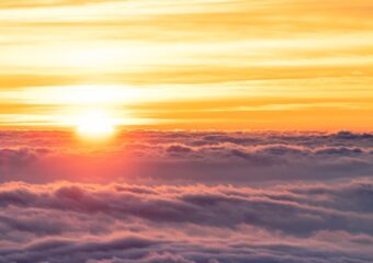 Sun on the horizon above the cloud layer.