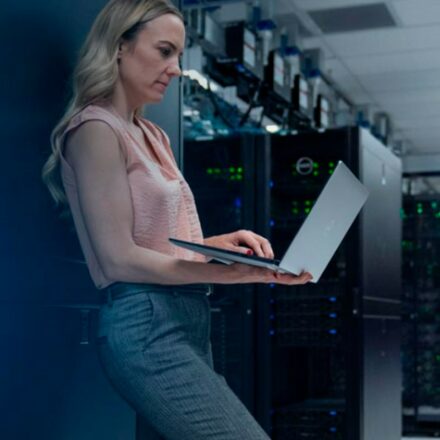 Woman referring to information on her Dell laptop while in a data center.