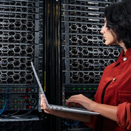 Female IT professional working in a data center with PowerEdge servers using a Dell XPS 13.