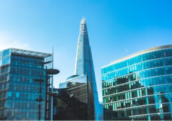 Skyscrapers in downtown London, UK, on a clear day, with blue sky behind the buildings.