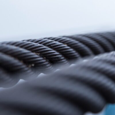 Closeup of steel cables, against a neutral color background.
