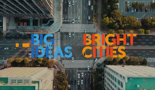 Overhead view of a street intersection in downtown or urban area, with the words "Big Ideas Bright Cities". 