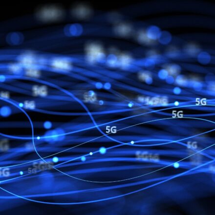 Digital image of 5G network data communications in progress, represented in blue light against a dark background.