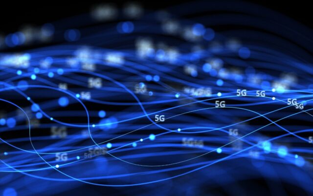 Digital image of 5G network data communications in progress, represented in blue light against a dark background.