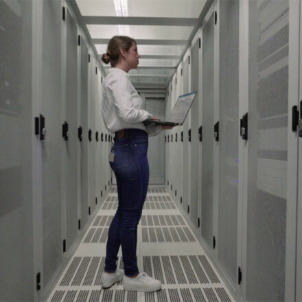 Female IT Pro using a Latitude 9430 notebook while inspecting data center operations.