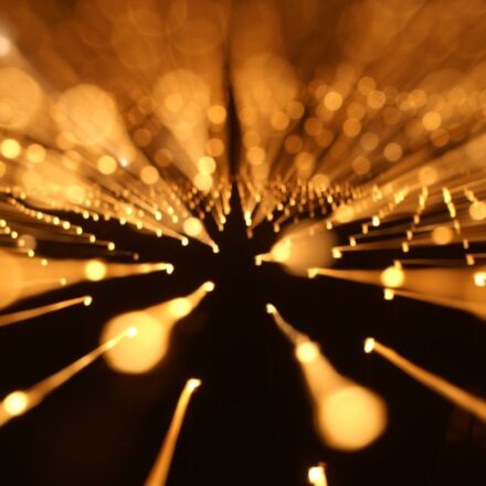 Digital image of gold color particles of light in motion.