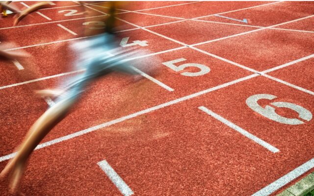 Runner nearing the finish line in a track and field race lane.