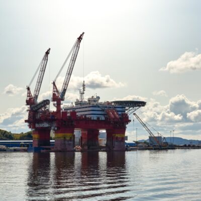 Oil drilling platform in the Norwegian Sea with a partly sunny sky in the background.