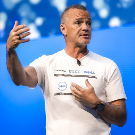 Jeff Clarke, Dell Technologies vice chairman and co-COO, on stage wearing a white t-shirt showing a timeline of Dell's corporate logos, speaks onstage at Day 2 of Dell Technologies World.