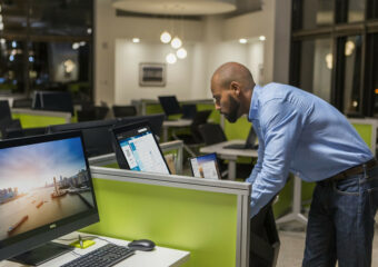 African-American male IT pro installs Dell ProDeployPlus on Dell systems in an office setting after hours.