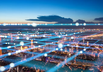 Digital overlay of digital networking communications over a cityscape at sunset.