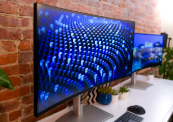 Dell UltraSharp 40 monitor on desk in front of a brick wall.