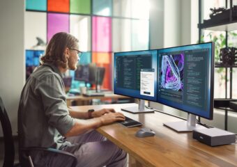 Professional working on a laptop in a modern office, representing AI powered PCs for workplace productivity with innovation and collaboration tools.