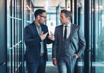 Two men talking about AI and security in a hallway